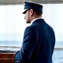 Experienced yacht captain in uniform, confidently looking out to sea.